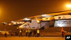 Para petugas mendorong pesawat Solar Impulse 2 ke hangar saat mendarat di bandara Ahmadabad, India, 11 Maret 2015 (AP Photo/Ajit Solanki).