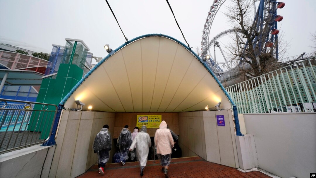 Participantes en un simulacro de ataque con misil balístico de Corea del Norte en Tokio ingresan a un refugio subterráneo, el lunes, 22 de enero de 2018.