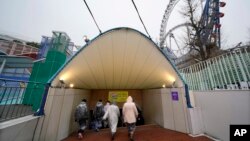 Participantes en un simulacro de ataque con misil balístico de Corea del Norte en Tokio ingresan a un refugio subterráneo, el lunes, 22 de enero de 2018.