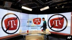 FILE - An employee of Crimean Tatar ATR TV walks in a studio in Simferopol, Crimea, March 31, 2015. Following Crimea's annexation by Russia in March of 2014, ATR lost its license and resumed broadcasting from Ukraine's capital, Kyiv, in June of 2015.