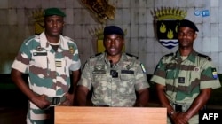 FILE - This video grab taken from a video obtained by AFPTV from GABON1 on September 6, 2023 shows Colonel Ulrich Manfoumbi Manfoumbi (C), spokesperson for the Gabonese transition, reading a statement on television freeing deposed president Ali Bongo.