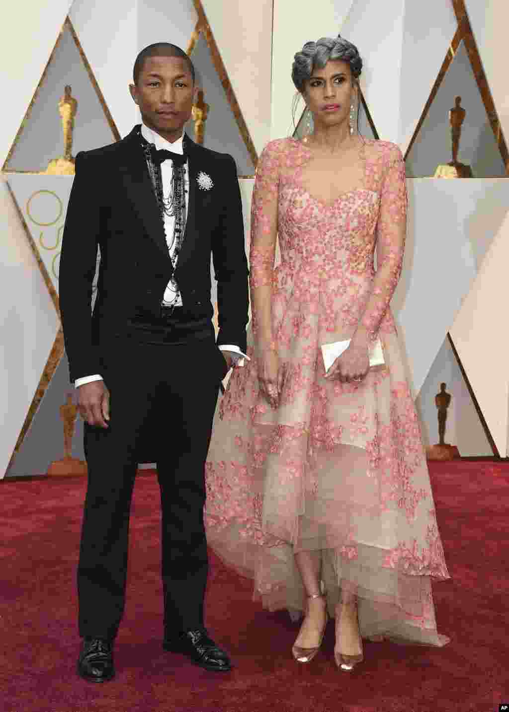 Pharrell Williams, a la izquierda, y Mimi Valdés llegan a los Oscar en el Teatro Dolby de Los Ángeles.