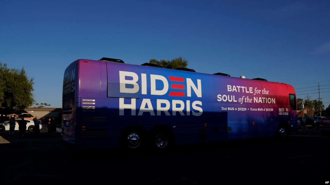 FILE - Democratic presidential candidate former Vice President Joe Biden and Democratic vice presidential candidate Sen. Kamala Harris, ride on a bus in Phoenix, Arizona, Oct. 8, 2020, on a small business bus tour. 