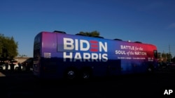 FILE - Democratic presidential candidate former Vice President Joe Biden and Democratic vice presidential candidate Sen. Kamala Harris, ride on a bus in Phoenix, Arizona, Oct. 8, 2020, on a small business bus tour. 