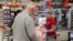 A cashier works behind a protective plexiglass shield at a supermarket in Sydney, Australia, Oct. 27, 2020.