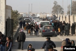 Pengungsi yang melarikan diri dari pedesaan Aleppo berjalan melewati mobil di Tabqa, Suriah 4 Desember 2024. (Orhan Qereman/REUTERS)