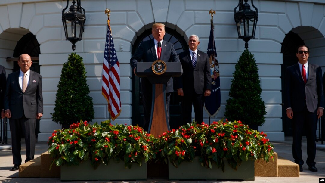 President Donald Trump delivers remarks about the economy on the South Lawn of the White House, July 27, 2018, in Washington. From left, Commerce Secretary Wilbur Ross, Trump, Vice President Mike Pence, and Treasury Secretary Steve Mnuchin.