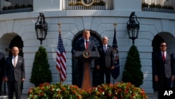 Presiden Donald Trump di pelataran selatan Gedung Putih, Washington, D.C, 27 Juli 2018. Didampingi Menteri Perdagangan Wilbur Ross (kiri), Wapres Mike Pence (dua dari kanan) dan Menteri Keuangan AS Steve Mnuchin.