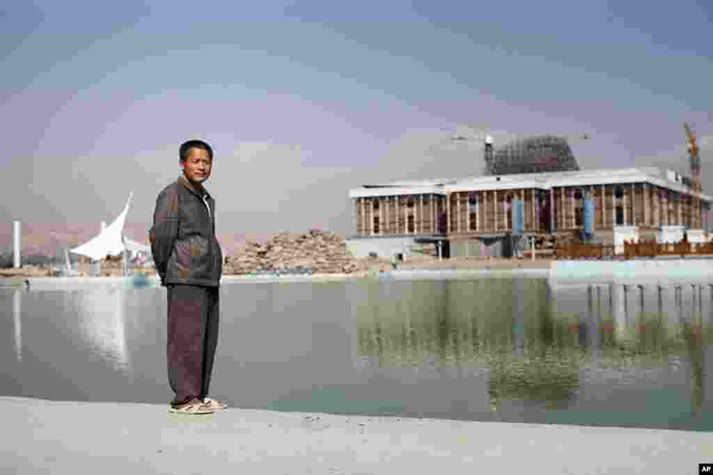 A Chinese construction worker stands in front of the new ministry of foreign affairs in downtown Dushanbe. (VOA - Y. Weeks)