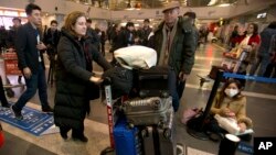 اورسلا گوتیه در فرودگاه پکن، وسایل خود را برای برای بازگشت به فرانسه حمل می کند.