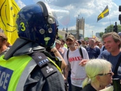 FILE - Protesters take part in an anti-lockdown demonstration in London's Parliament Square amid coronavirus disease (COVID-19) pandemic, in London, July 19, 2021.