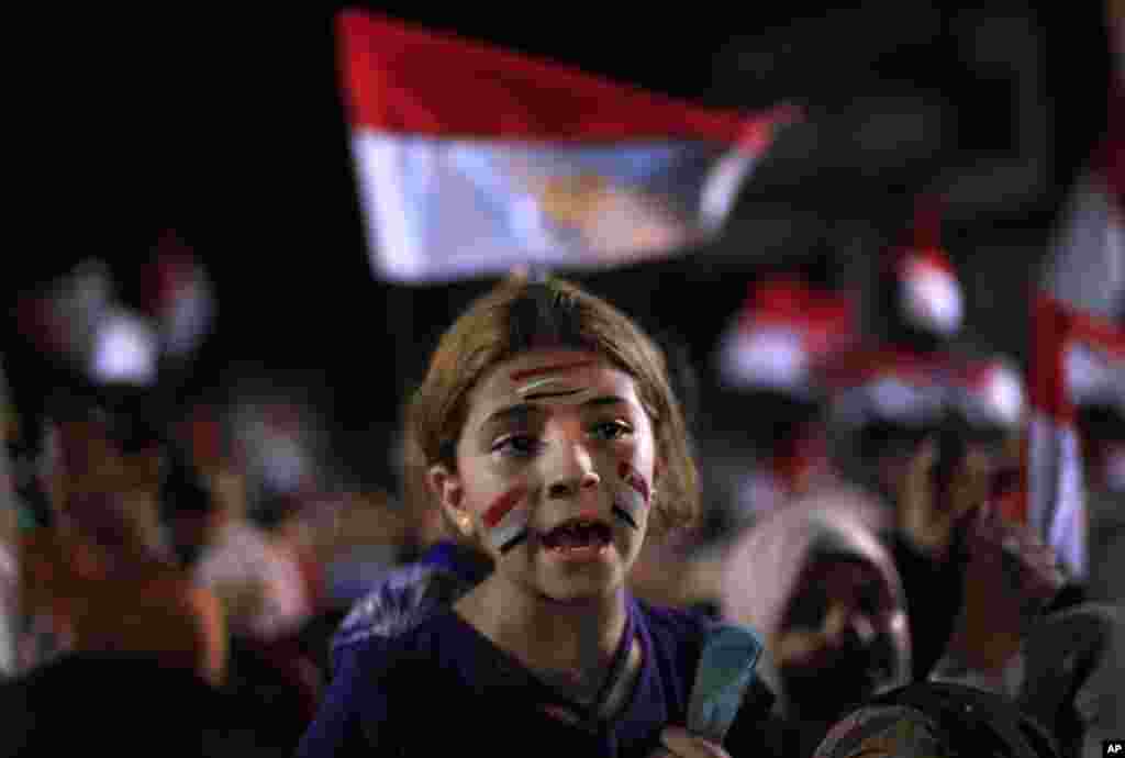 An Egyptian girl has a face painting with the colors of the national flag and attends a protest outside Rabaah al-Adawiya mosque at Nasr City in Cairo, August 6, 2013.