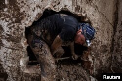 Muškarac traga za žrtvama nakon klizišta u poplavljenom selu Donja Jablanica, Bosna i Hercegovina, 5. oktobar 2024. (Foto: Rojters/Marko Đurica)