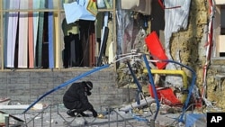 An investigator works at the scene of one of two explosions near the city's market in the eastern Ukrainian town of Makiyivka, 20 Jan 2011