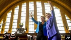 Democratic presidential candidate Hillary Clinton, accompanied by Sen. Elizabeth Warren, D-Mass., left, waves after speaking at the Cincinnati Museum Center at Union Terminal in Cincinnati, June 27, 2016.