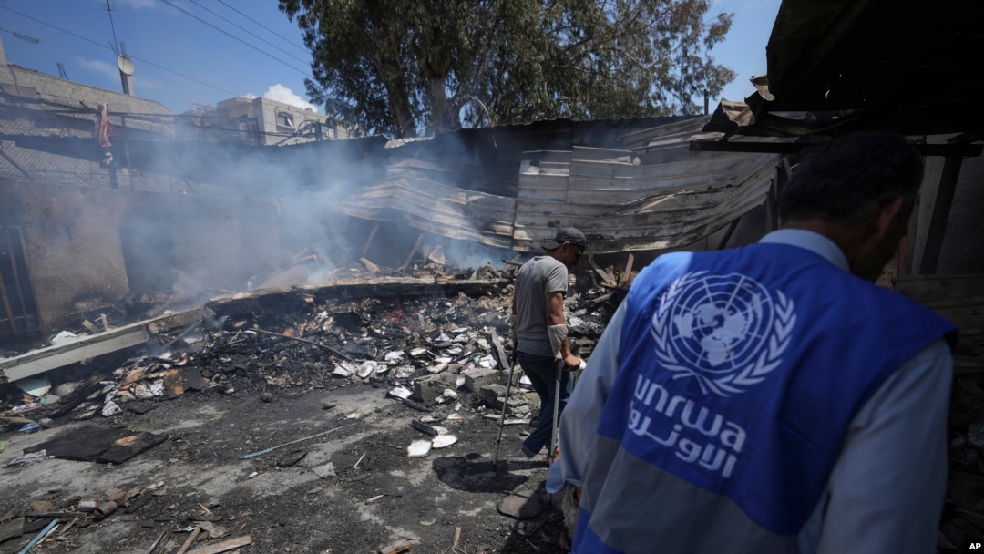 ARCHIVO. - Los palestinos observan la destrucción después de un ataque israelí contra una escuela dirigida por la UNRWA, la agencia de las Naciones Unidas que ayuda a los refugiados palestinos, en Nuseirat, Franja de Gaza, 14 de mayo de 2024. AP