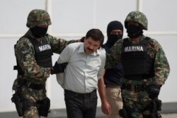 Joaquin "El Chapo" Guzman is escorted to a helicopter in handcuffs by Mexican navy marines at a navy hanger in Mexico City, Mexico, Feb. 22, 2014.