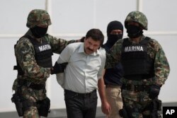 FILE - Joaquin "El Chapo" Guzman is escorted to a helicopter in handcuffs by Mexican navy marines at a navy hanger in Mexico City, Mexico, Saturday, Feb. 22, 2014.
