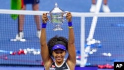 Naomi Osaka, of Japan, holds up the championship trophy after defeating Victoria Azarenka, of Belarus, in the women's singles final of the U.S. Open tennis championships, Sept. 12, 2020, in New York.