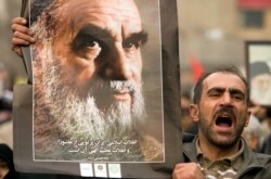 FILE - A man holds a picture of Ayatollah Ruhollah Khomeini, founder of the Islamic Republic, as government supporters protest against opposition demonstrations during the holy day of Ashura, in Tehran, Dec. 30 2009.