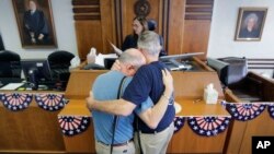 Pasangan Gerald Gafford (kanan) dan Jeff Sralla menerima surat yang memperbolehkan mereka untuk menikah di Austin, Texas (26/6). (AP/Eric Gay)