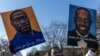 A protester holds placards with the pictures George Floyd and Ahmaud Arbery