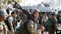 Cambodian soldiers carry their weapons near Preah Vihear temple along the border with Thailand February 6, 2011. Thai and Cambodian soldiers exchanged fire on a disputed stretch of their border on Sunday, witnesses said, the third flare-up in three days i