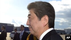 Japanese Prime Minister Shinzo Abe, foreground and his wife, Akie, arrive at the Helsinki International Airport in Vantaa, Finland, July 9, 2017. 