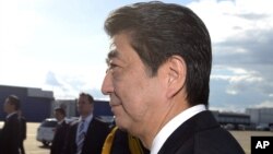 Japanese Prime Minister Shinzo Abe, foreground and his wife Akie arrive at the Helsinki International Airport in Vantaa, Finland, Sunday, July 9, 2017. 
