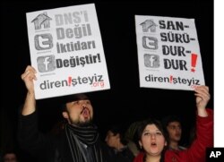FILE - People hold placards that read "stop censorship" during a rally against proposed government curbs on access to some websites in Ankara, Turkey, Jan. 18, 2014.