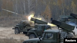 FILE - Ukrainian servicemen fire BM-21 Grad multiple rocket launcher systems during military exercises near the village of Divychky in the Kyiv region of Ukraine, Oct. 28, 2016.