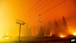 Seen in a long camera exposure, the Caldor Fire burns at the Sierra-at-Tahoe ski resort on Aug. 29, 2021, in Eldorado National Forest, Calif. 