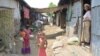 Displaced children and women are seen in run-down UN shelters in Baw Du Pha Camp 1 outside Sittwe. (P. Vrieze for VOA)