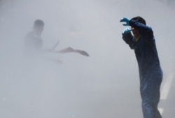 FILE - Nepalese police use water cannon to disperse youth who gathered for a protest near the prime minister's residence demanding better handling of the COVID-19 pandemic in Kathmandu, Nepal, June 11, 2020.