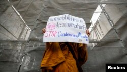 Phra Shine Waradhammo, biksu Thailand, memegang pakat bertuliskan "Hentikan Mengutuk Aborsi" dalam aksi demo di depan parlemen Thailand di Bangkok, 25 Januari 2021. (Foto: Krit Phromsakla Na Sakolnakorn / Thai News Pix).