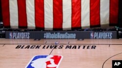 La cancha en la que se debían enfrentar los Bucks de Wisconsin y los Magic de Orlando quedó vacía y no hubo partido. En el piso de la cancha se lee en letras negras "Las Vidas Negras Importan".
