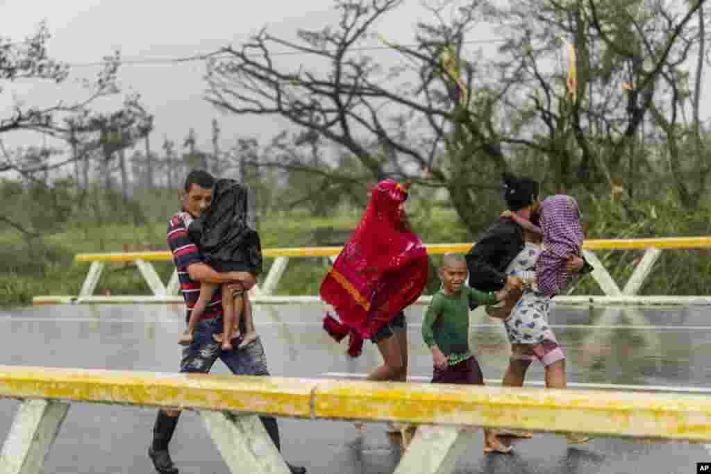 Una familia camina bajo la lluvia después de que el huracán Ian azotara Pinar del Río, Cuba, el martes 27 de septiembre de 2022. (Foto AP/Ramón Espinosa)