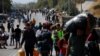 Migrants carry their belongings as they flee from Moria to the capital of Mytilene, on the northeastern island of Lesbos, Greece, Sept. 17, 2020.