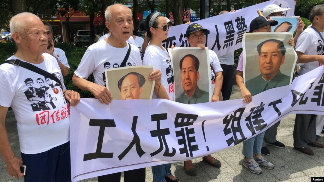 人们在中国广东省深圳市坪山区燕子岭派出所外示威，手持标语，支持佳士工厂工人组建工会要求。(2018年8月6日)