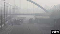 ভারতের নয়া দিল্লিতে এক ধোঁয়াটে সকালে বাস ডিপোর ভিতরে একজন ব্যক্তি ঝাড়ু দিচ্ছেন।১৬ নভেম্বর ২০২১।(ছবি-রয়টার্স/আনুশ্রি ফাডনাভিস)