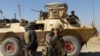 Afghan security forces stand near an armored vehicle during fighting between Afghan security forces and Taliban fighters in the Busharan area on the outskirts of Lashkar Gah, the capital of Helmand province, May 5, 2021. 