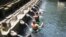 Turis asing mandi-mandi di air mancur Tirta Empul di Bali. 