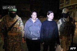 FILE —An image released by the Hamas Media Office shows the release of Israeli hostages Shiri Weiss (L) and her daughter Noga, to a Red Cross vehicle, in the Gaza Strip early on November 26, 2023.