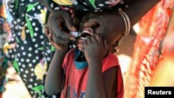 FILE - A displaced South Sudanese child receives an oral cholera vaccine in a camp for internally displaced people in the United Nations Mission in South Sudan compound in Tomping, Juba, Feb. 2014.