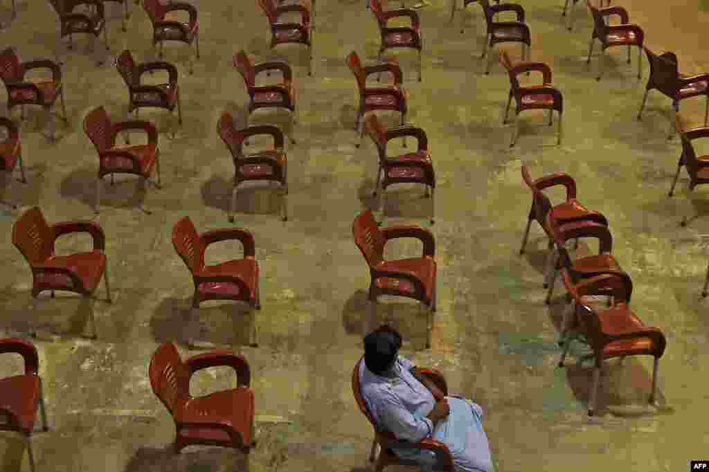 A man waits to get inoculated with the COVID-19 vaccine at a vaccination center in Karachi, Pakistan.