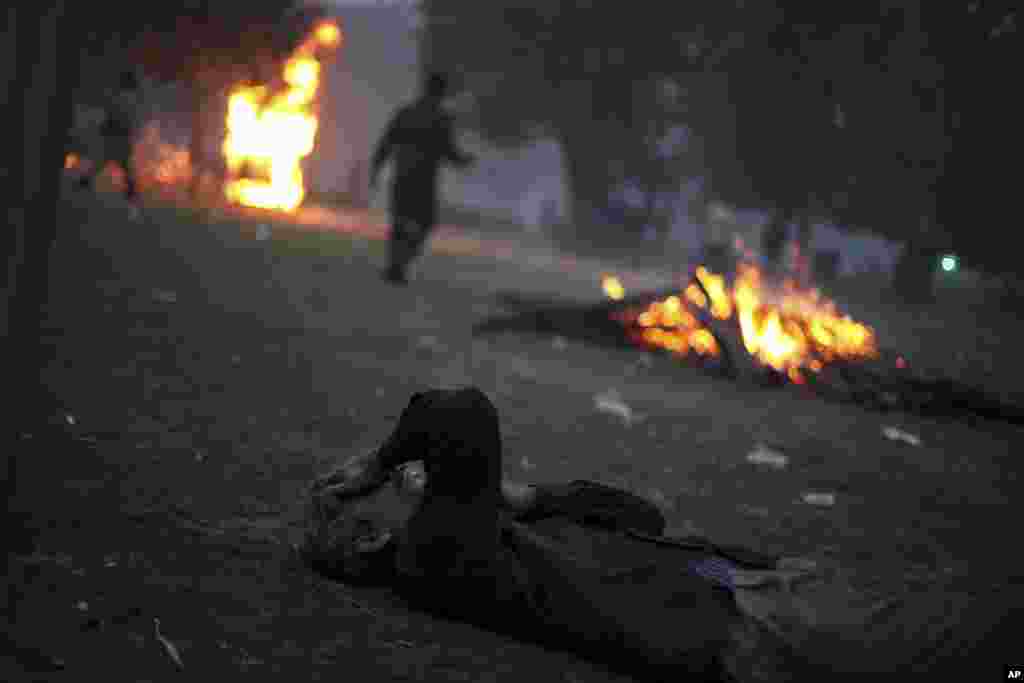 An Indian man overwhelmed by tear gas lies on the ground during a protest in New Delhi, India, December 23, 2012. 