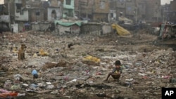 FILE- An Indian boy defecates in the open in a poor neighborhood of New Delhi, India, Nov. 6, 2012.