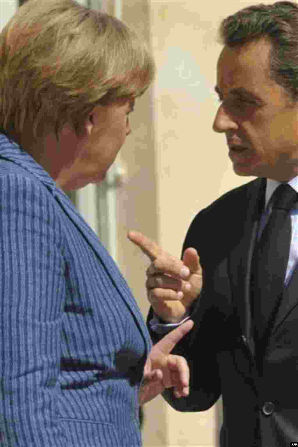 France's President Nicolas Sarkozy, right, and German Chancellor Angela Merkel gesture to each other prior to meeting at the Elysee Palace, Tuesday Aug. 16, 2011. (AP Photo/Philippe Wojazer, Pool)