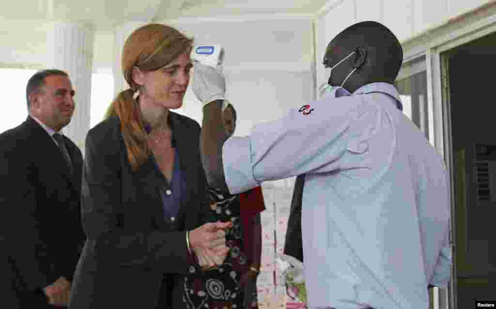 Samantha Power sanitizes her hands and has her temperature taken at the Guinea headquarters for the United Nations Ebola response mission, known as UNMEER, in Conakry, Guinea, Oct. 26, 2014.