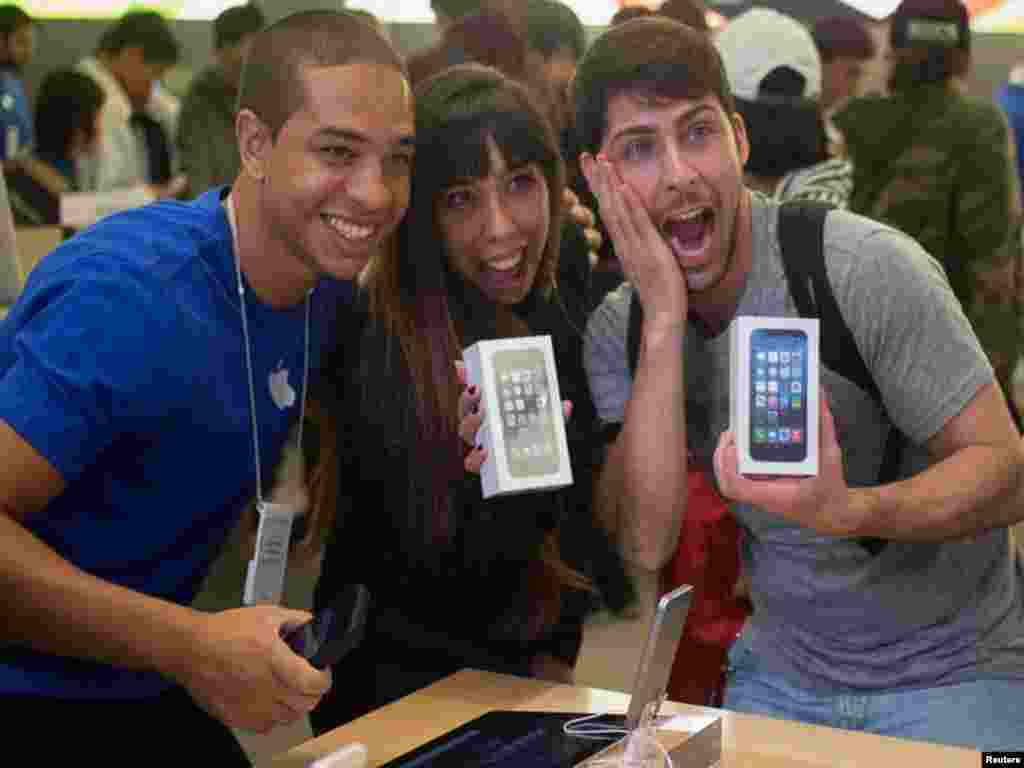 نیویارک میں ایپل فون کے دو کسٹمر ایپل کمپنی کے ملازم کے ساتھ نئے ایپل آئی فون کے ساتھ تصویر بنوارہے ہیں، گزشتہ روز ایپل فون کا نیا ماڈل فائیو سی اور فائیو ایس کو آسٹریلیا اور چین سمیت دنیا بھر میں فروخت کیلئے پیش کردیا گیا ہے۔